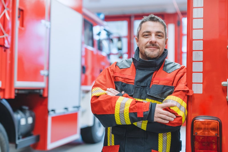 Feuerwehrmann in Garage mit Fahrzeugen